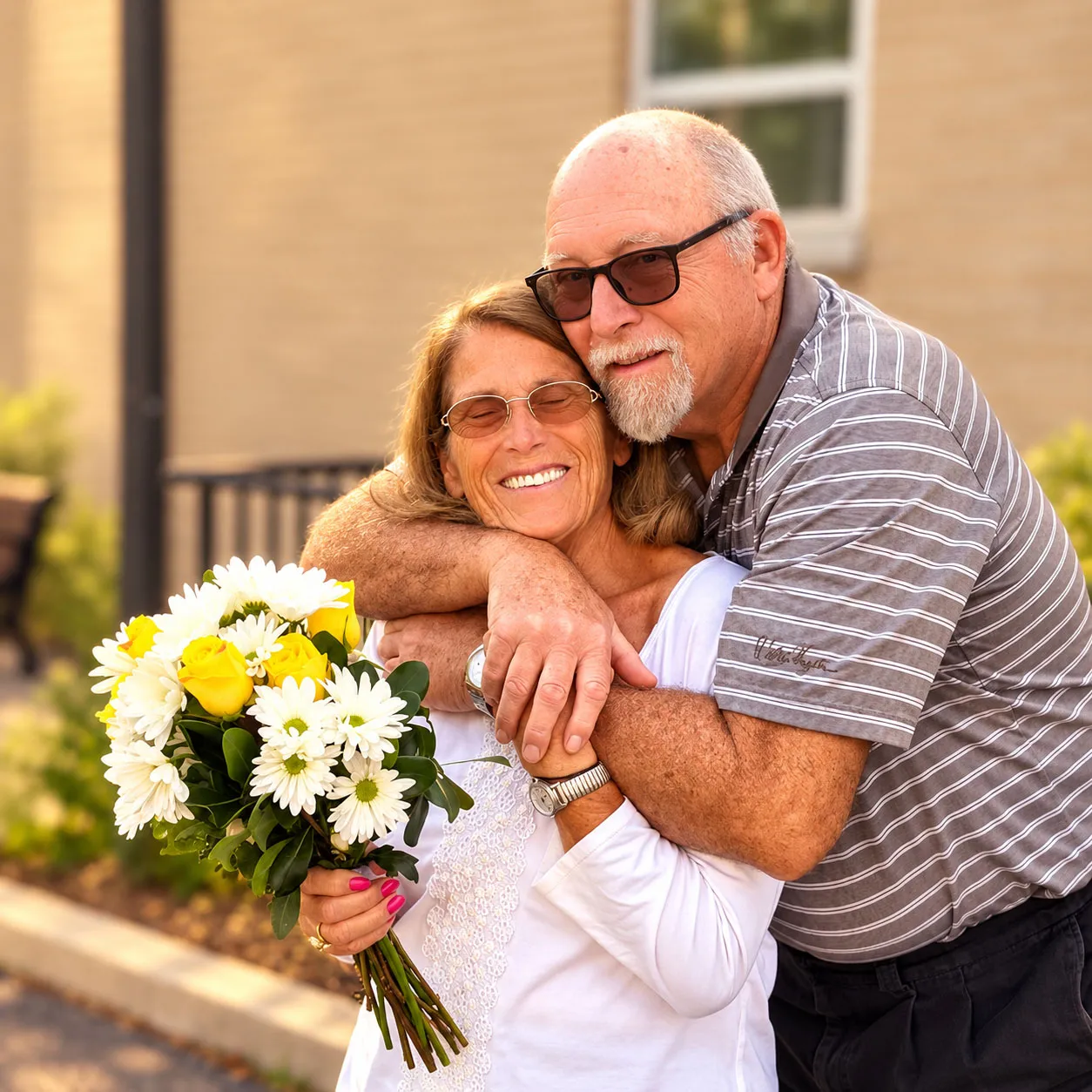 Emily Raffel smiling with a bouquet of daisies and yellow roses while getting a hug